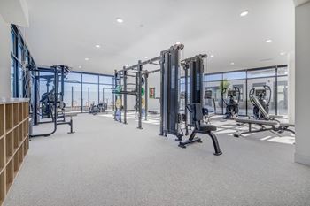 A gym with a variety of equipment including treadmills, weights, and exercise machines.